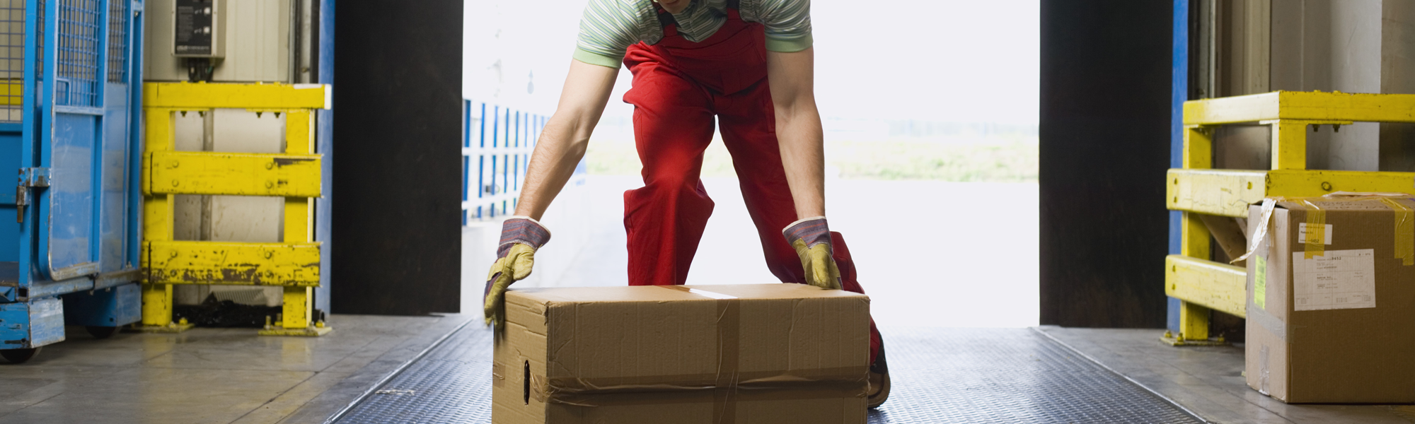 Worker preparing to lift box in warehouse